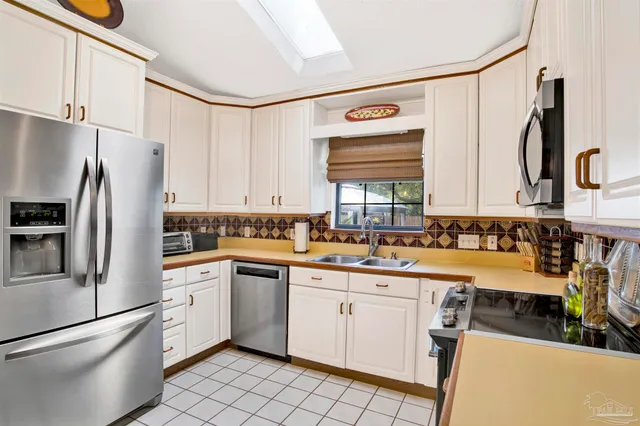 a kitchen with a sink a refrigerator and cabinets