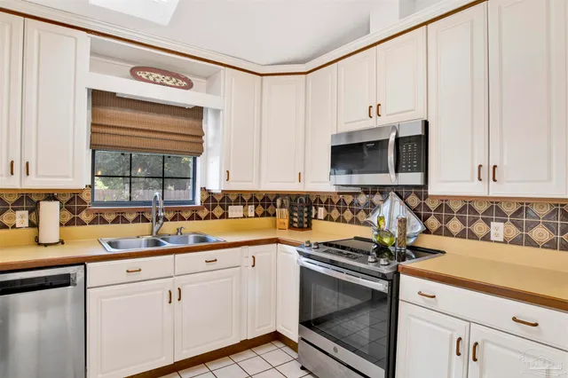 a kitchen with granite countertop a sink a stove and cabinets