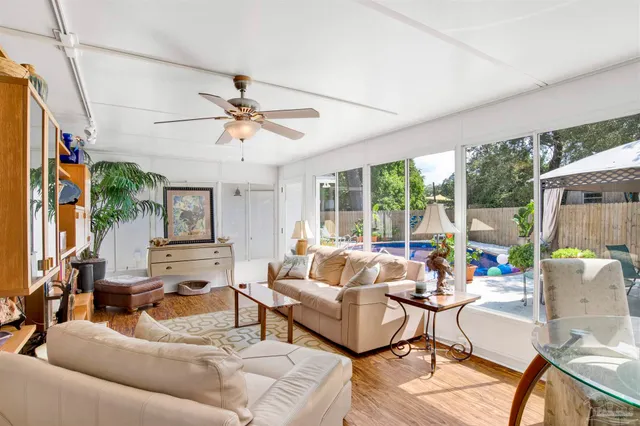 a living room with furniture ceiling fan and a large window