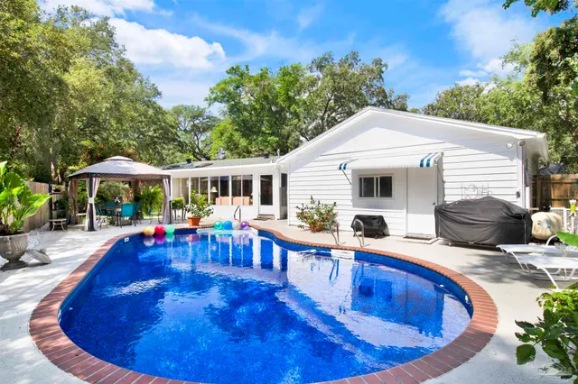 a view of a house with swimming pool and sitting area