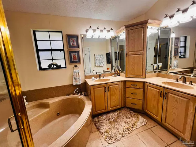 a bathroom with a tub sink and mirror