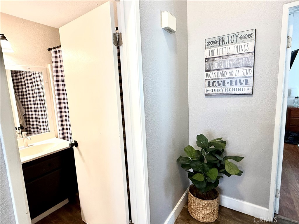 377 Quandt Ranch Road San Jacinto, CA 92583 - Photo 19 of 37 a view of a hallway with wooden floor and a potted plant