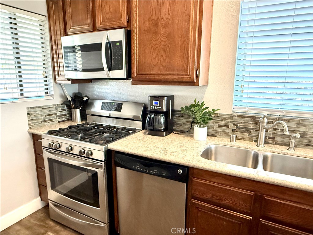 377 Quandt Ranch Road San Jacinto, CA 92583 - Photo 9 of 37 a kitchen with granite countertop a stove sink and microwave