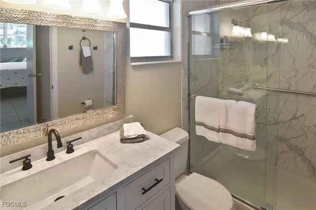 a bathroom with a granite countertop sink toilet and shower