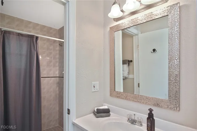 a bathroom with a sink a mirror and a shower