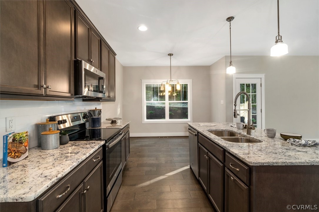 a kitchen with granite countertop stainless steel appliances a sink stove and cabinets