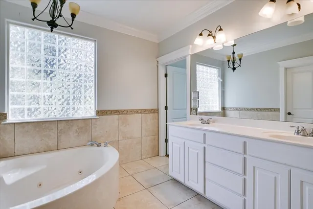 a bathroom with a tub a sink and mirror