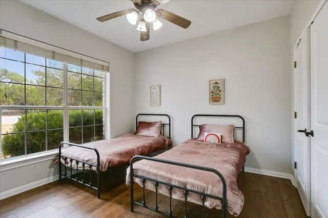 a bedroom with two beds and a large window
