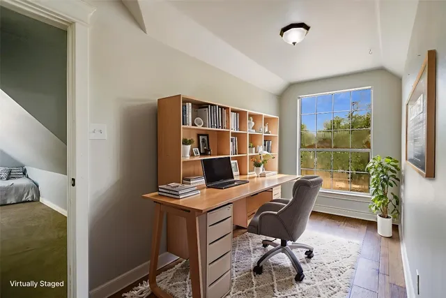 a view of a workspace with furniture and a window