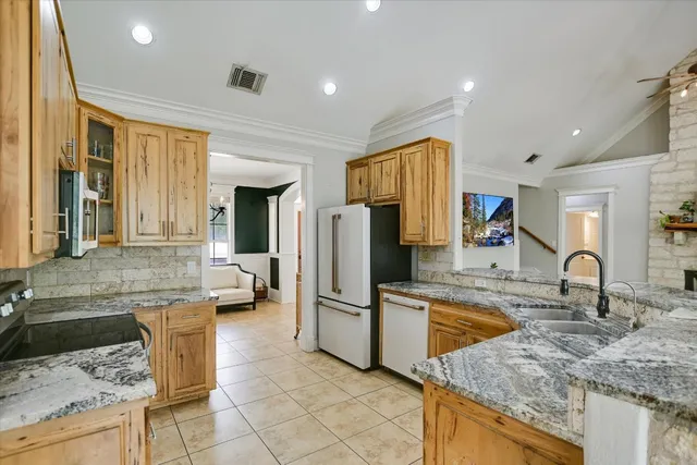 a kitchen with stainless steel appliances granite countertop a sink and a refrigerator