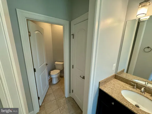a bathroom with a granite countertop sink toilet and shower a mirror