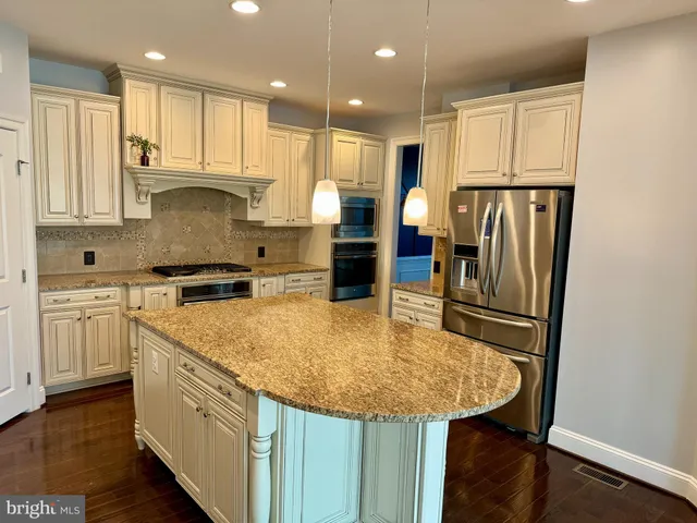 a kitchen with stainless steel appliances granite countertop a sink refrigerator and cabinets