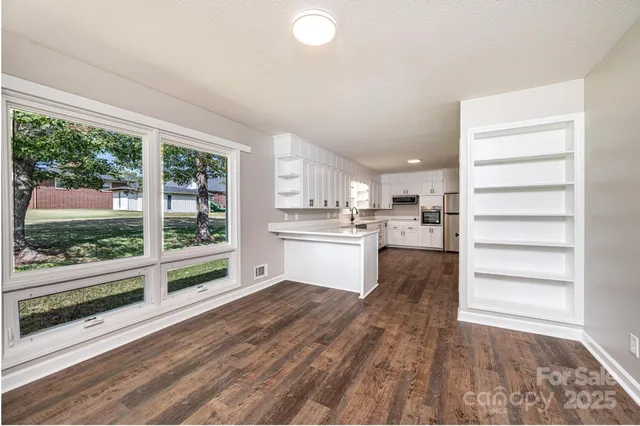 a view of a kitchen with wooden floor and electronic appliances