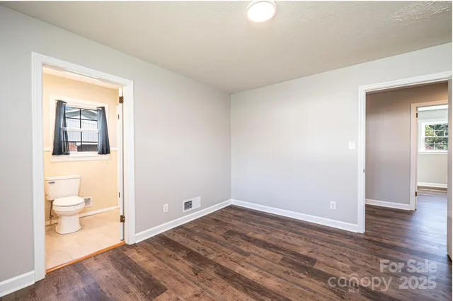 a view of a room with wooden floor and bathroom view