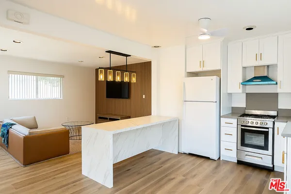 a kitchen with a refrigerator and a stove top oven
