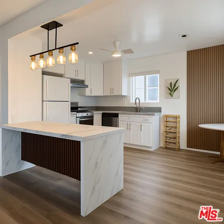 a kitchen with kitchen island a sink dishwasher a stove and a refrigerator with wooden floor