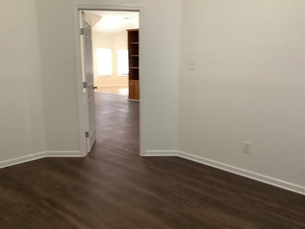 1601 Oak Pl Court Pearland, TX 77581 - Photo 19 of 21 an empty room with wooden floor & windows