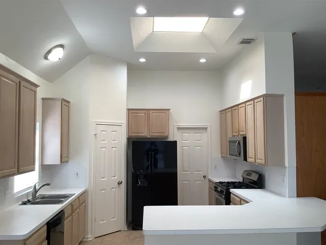 a kitchen with stainless steel appliances a refrigerator sink and stove