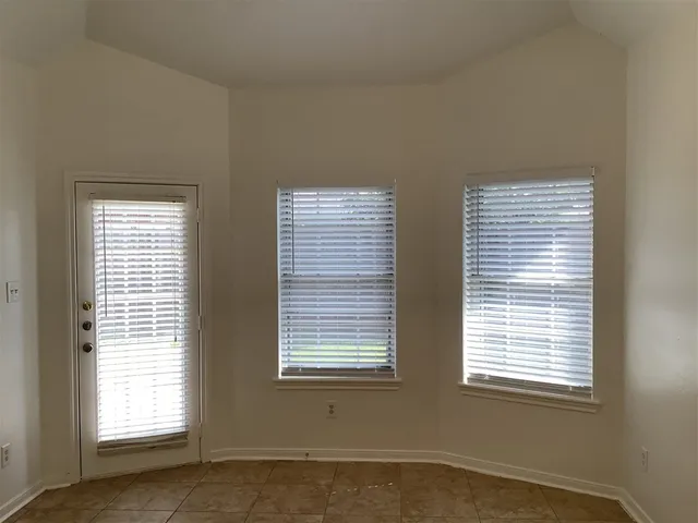 an empty room with two windows