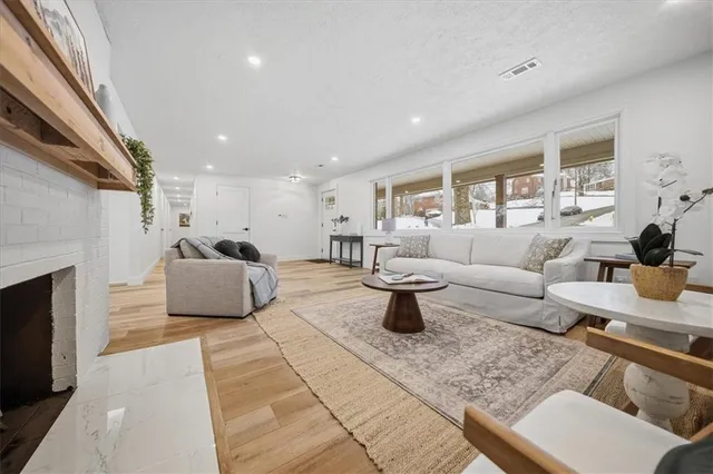a living room with furniture a fireplace and a potted plant