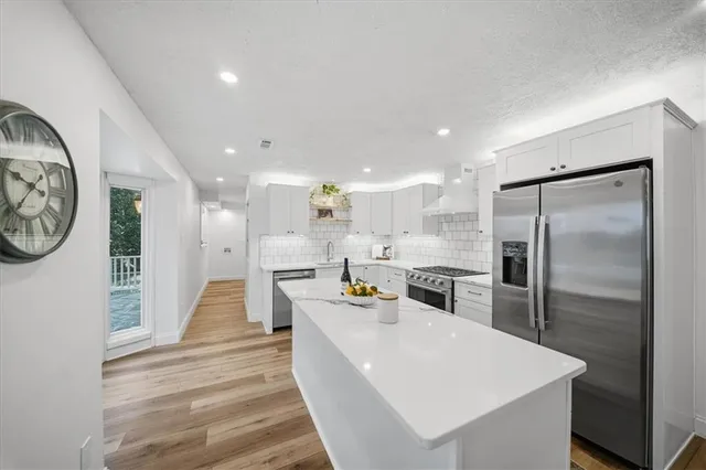 a large white kitchen with sink stove and white cabinets