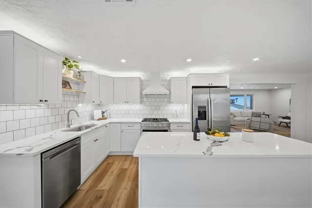 a kitchen with a sink cabinets stainless steel appliances and a window