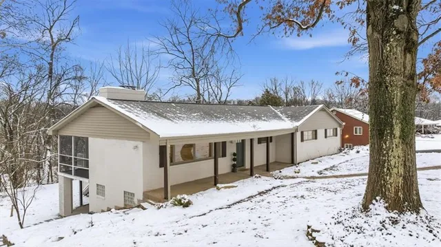 a front view of a house with a yard covered in snow