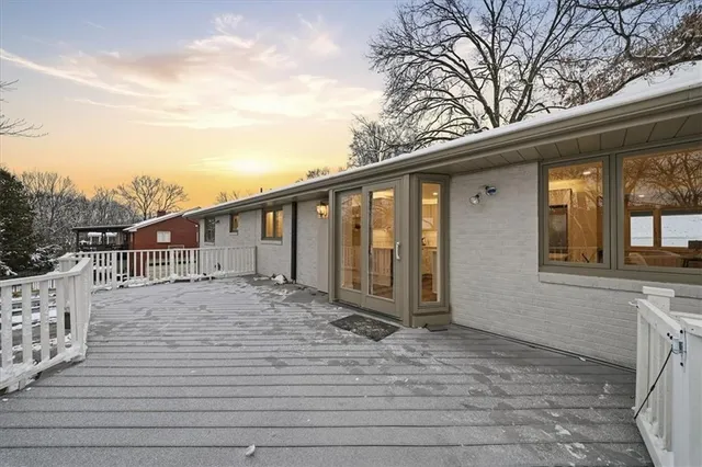a view of backyard with large trees and wooden fence