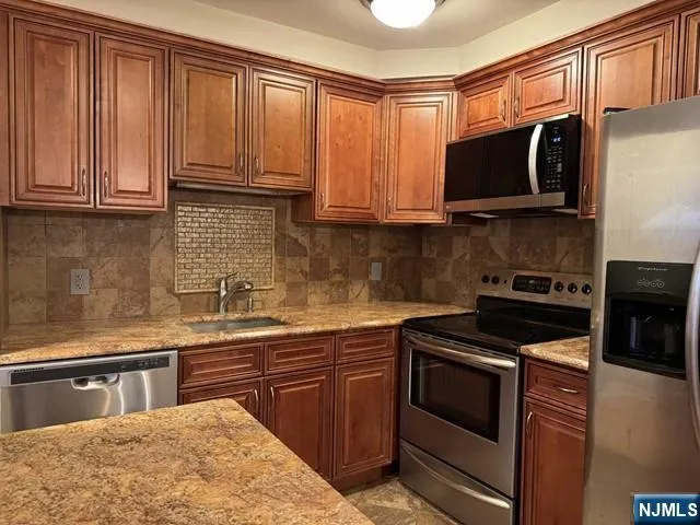 a kitchen with stainless steel appliances granite countertop a stove microwave and sink