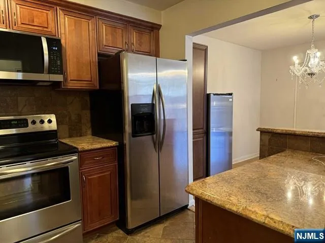 a kitchen with stainless steel appliances granite countertop a refrigerator stove and microwave