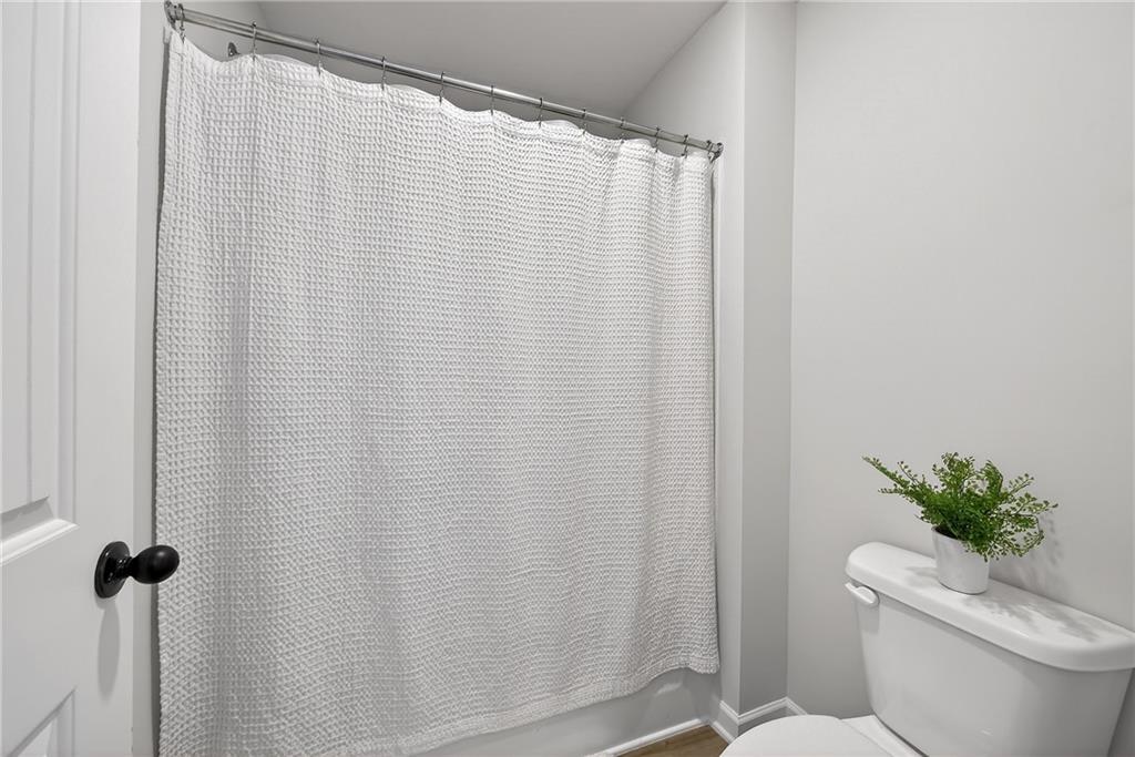 4827 Sultana Way Atlanta, GA 30331 - Photo 22 of 24 a white toilet sitting next to a shower curtain
