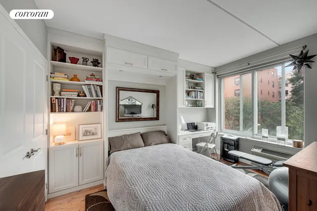 a bedroom with a bed furniture and a large window