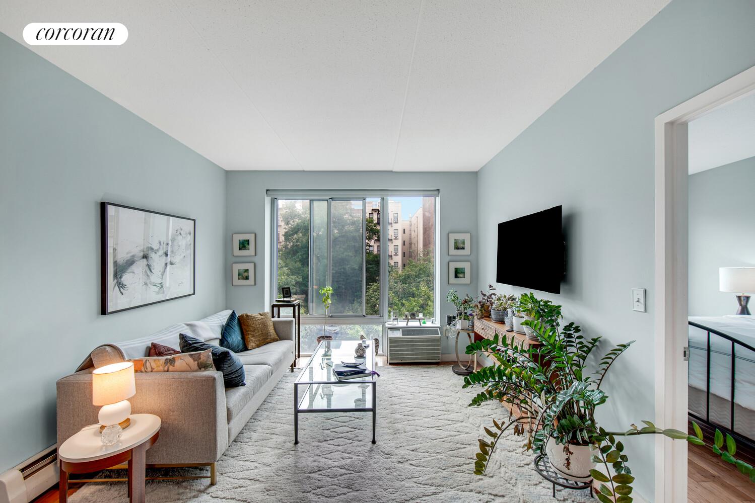 29 West 138th Street, Unit 4H Manhattan, NY 10037 - Photo 2 of 15 a living room with furniture and a flat screen tv