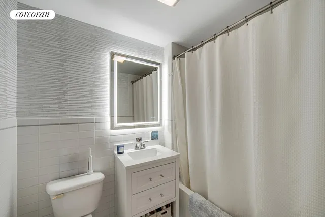 a bathroom with a toilet a sink and curtain