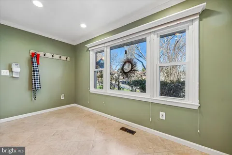an empty room with a chandelier fan and windows