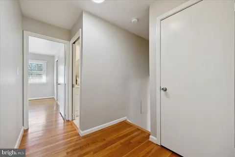 a view of empty room with wooden floor and fireplace
