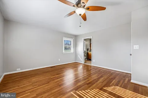 a view of a room with wooden floor and fan
