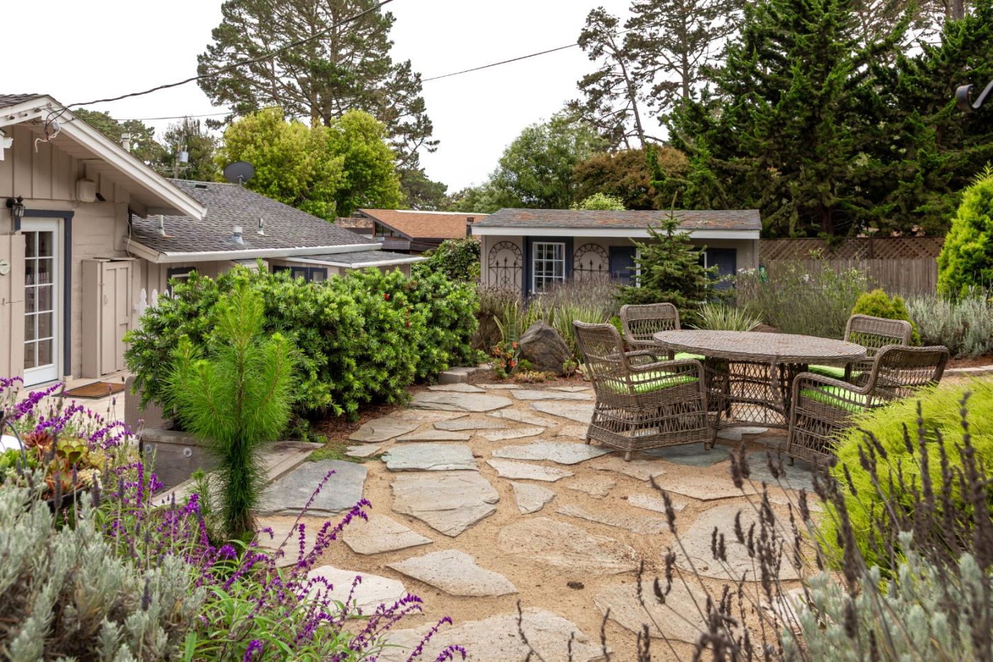 4106 Crest Road Pebble Beach, CA 93953 - Photo 36 of 43 a view of a patio with table and chairs potted plants and large tree