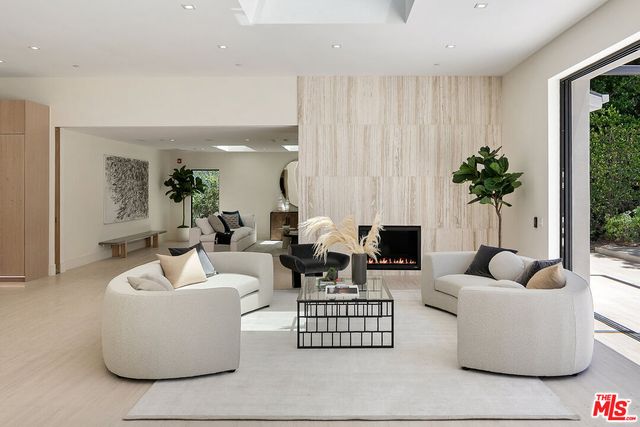 a living room with furniture a fireplace and a potted plant
