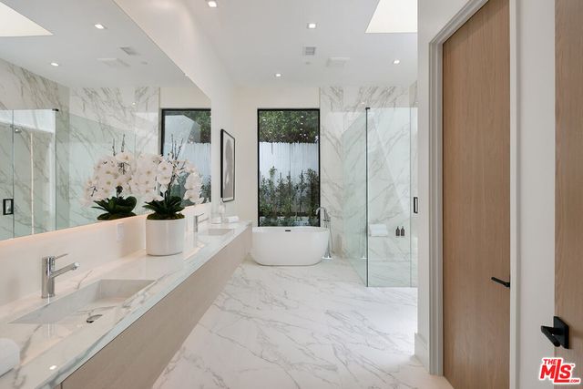 a bathroom with a tub shower and sink