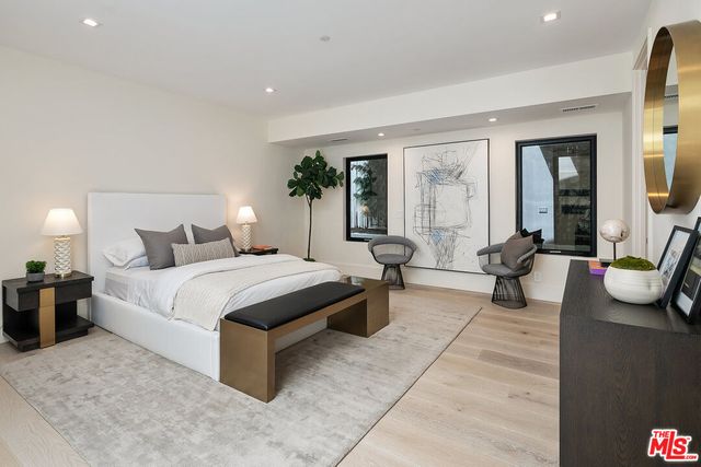 a spacious bedroom with a bed a couch and dresser