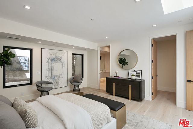 a bed room with a bed a mirror and a large window