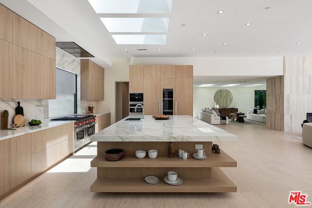 a large kitchen with stainless steel appliances granite countertop a stove and a sink