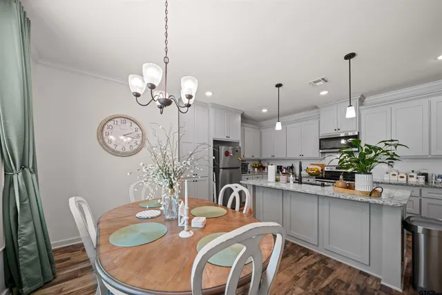 a dining room filled chandelier and kitchen view