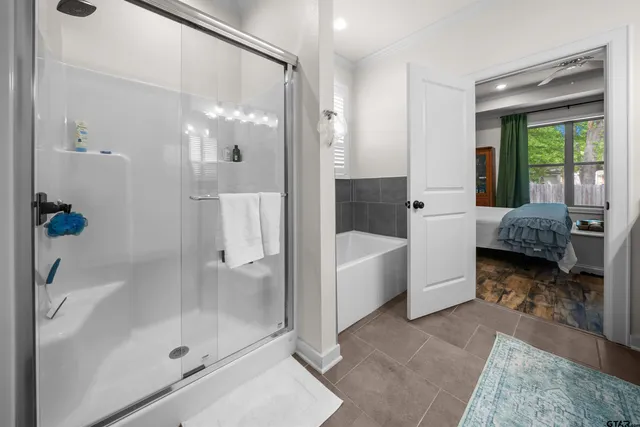 a bathroom with a tub shower and window
