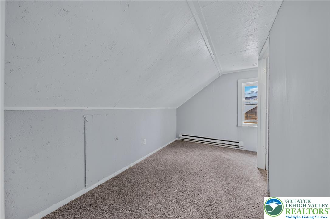 313 Main Street Slatington, PA 18080 - Photo 57 of 73 A versatile attic space featuring warm carpeted flooring and a charming window, ready for personalization.