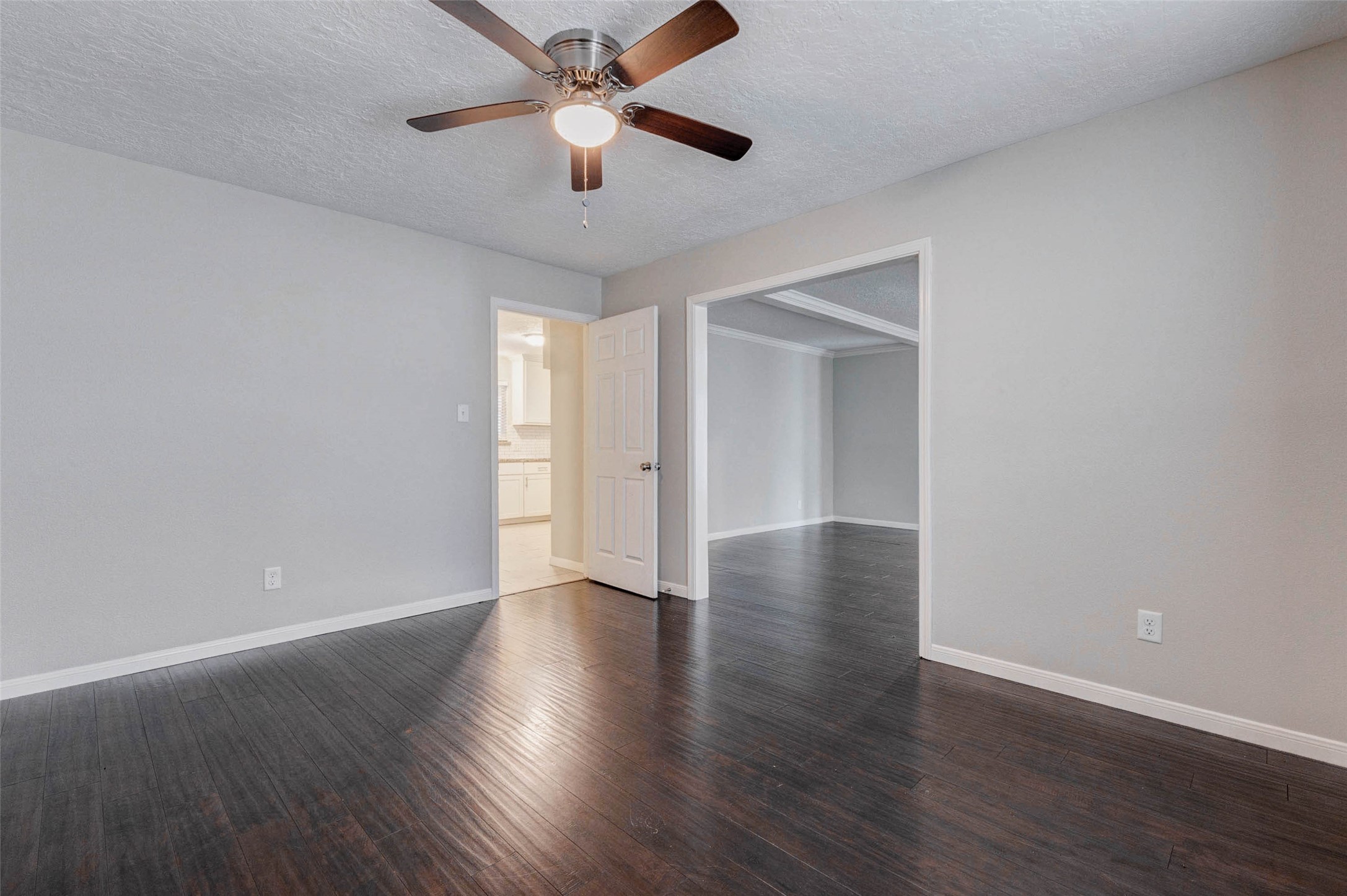 1622 Elk River Road Houston, TX 77090 - Photo 12 of 40 an empty room with wooden floor and a ceiling fan