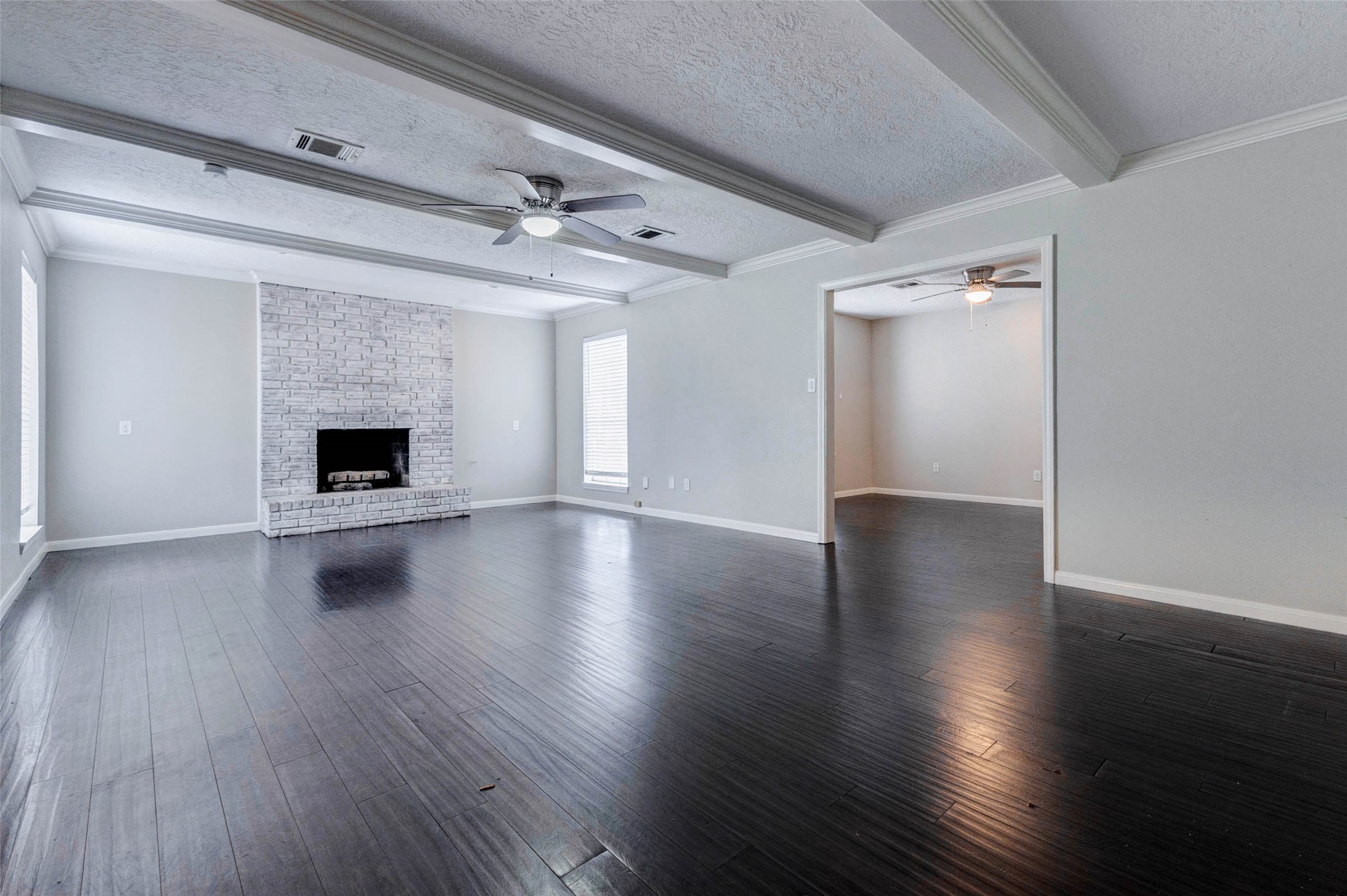 1622 Elk River Road Houston, TX 77090 - Photo 8 of 40 an empty room with wooden floor fireplace and windows