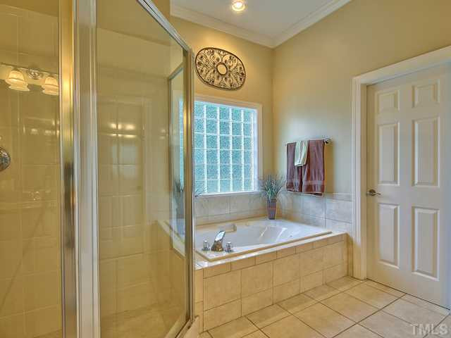 1812 Stannard Trail Raleigh, NC 27612 - Photo 13 of 25 The master bath offers both a large walk-in shower with tile surround and a large soaking tub with a tile surround as well. A glass block window provides both light and privacy. Master Bath/Spa