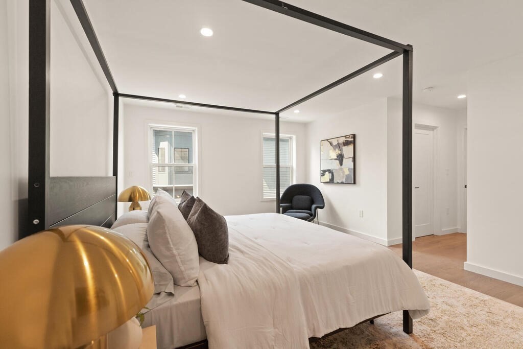 70 Walker Street, Unit 4 Newton, MA 02460 - Photo 15 of 35 a bedroom with a large bed and a chandelier